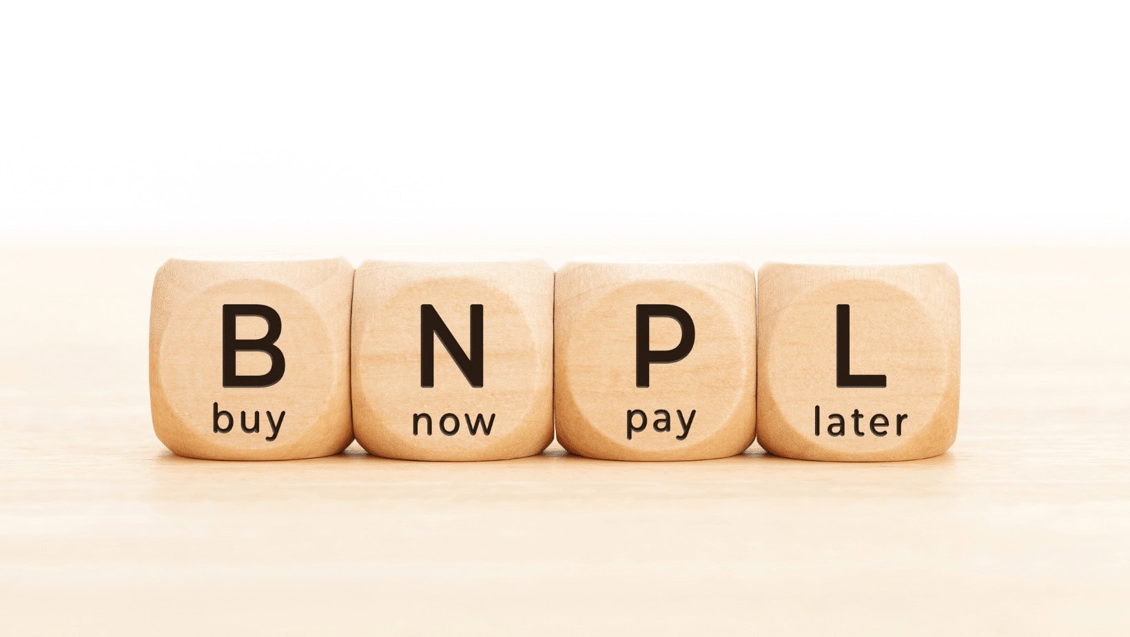 Wooden blocks spelling B-N-P-L for Buy Now Pay Later.