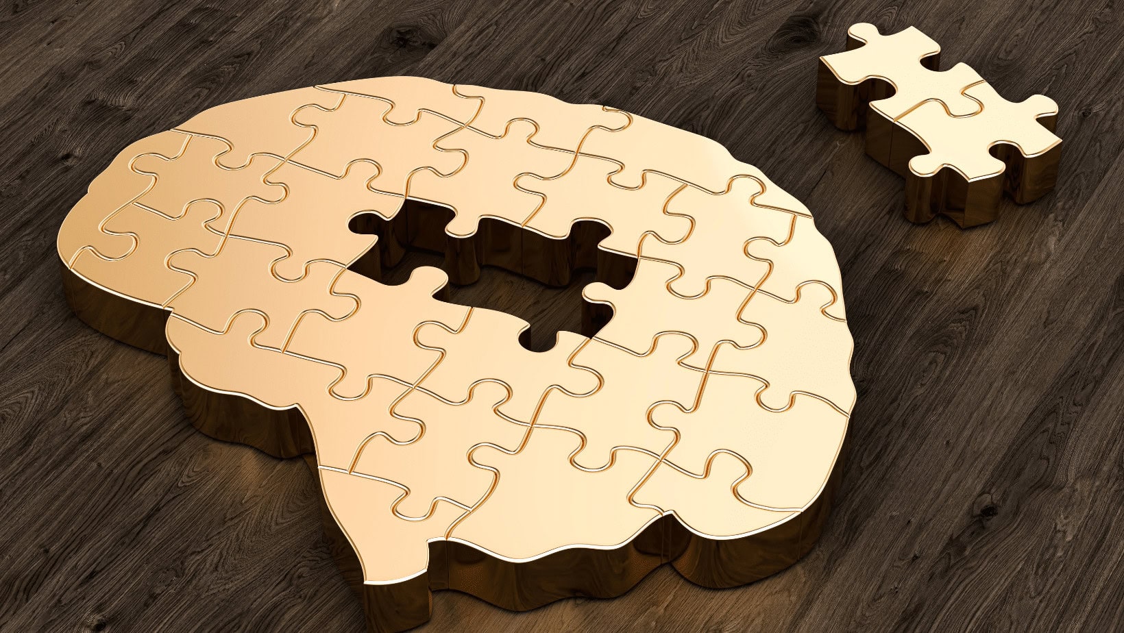 Wooden brain puzzle with missing piece on dark wooden surface.