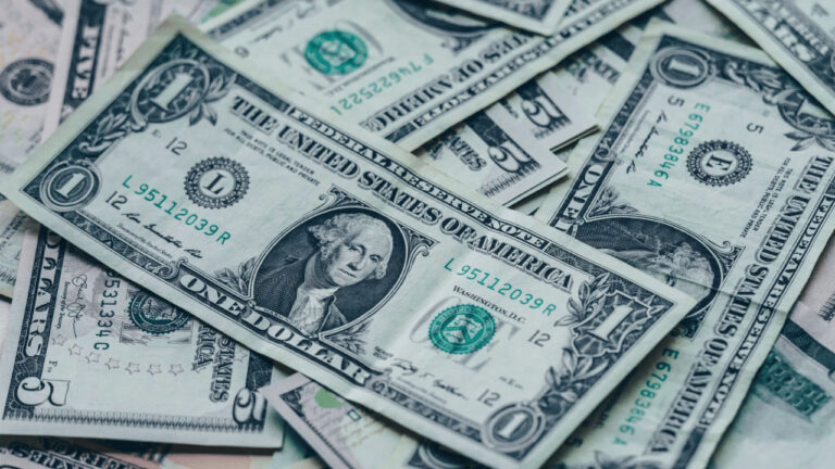 Stack of US dollar bills representing retirement savings and financial planning.