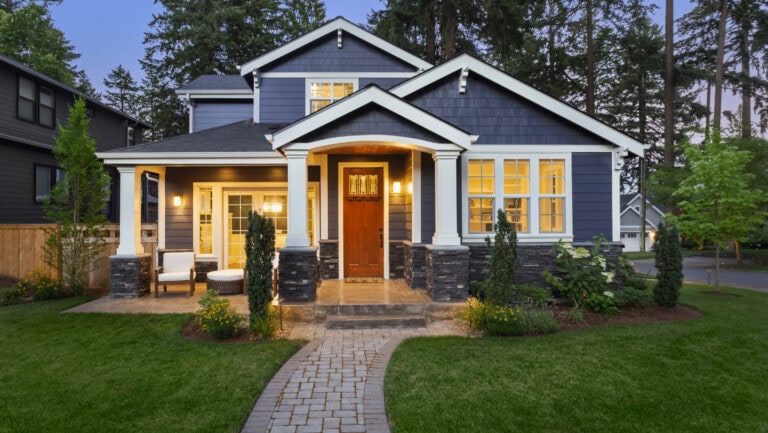Modern blue house with well-maintained lawn and pathway.