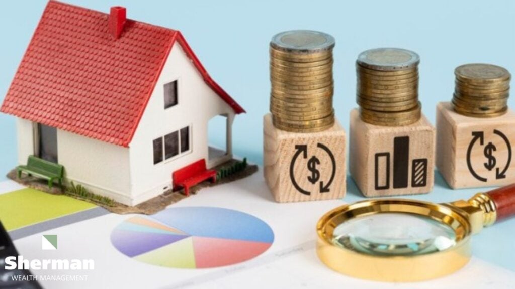 Model house on stacked coins beside financial planning documents for year-end planning